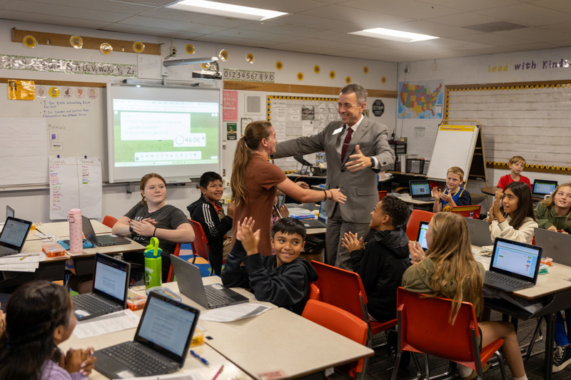 Dr. Jackson embraces Ms. Van Etten as her students clap