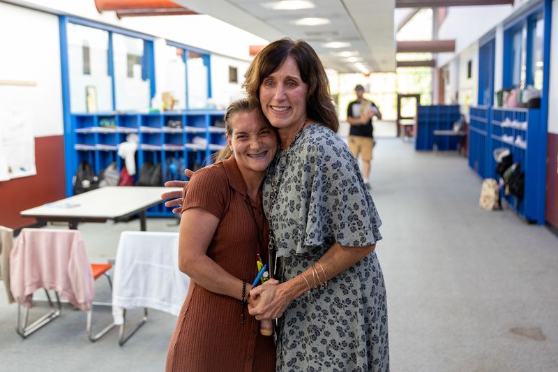 Ms. Van Etten and Ms. O'Connell embrace in the hallway at W.D. Williams Elementary