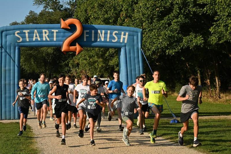 Runners going through the starting arch at the Carolina Comeback 5k event.