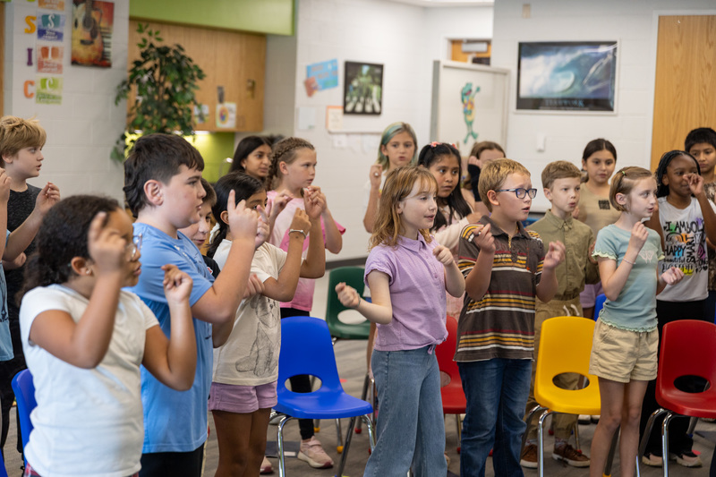 Students snapping their fingers as they sing a song
