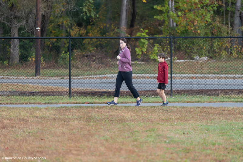 Parent volunteer walking with student. 