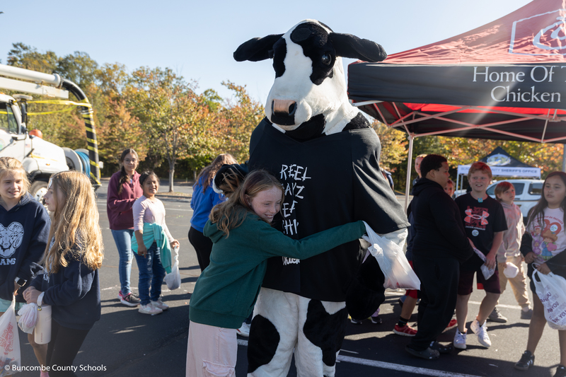 Girl giving the Chick-Fil-A cow a hug. 