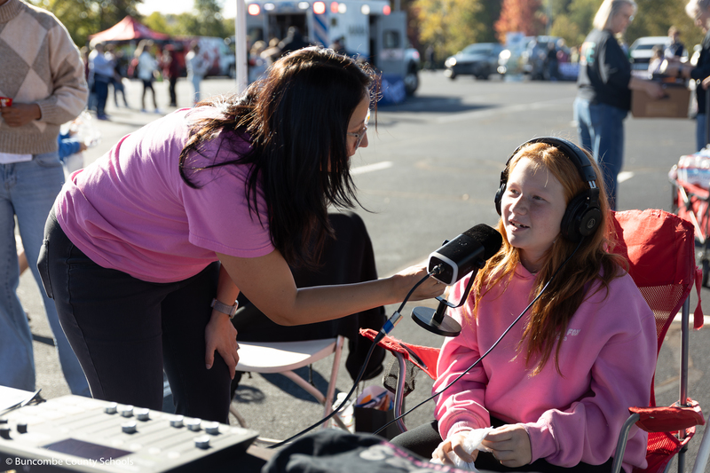 Girl talking into a microphone with a local radio station. 