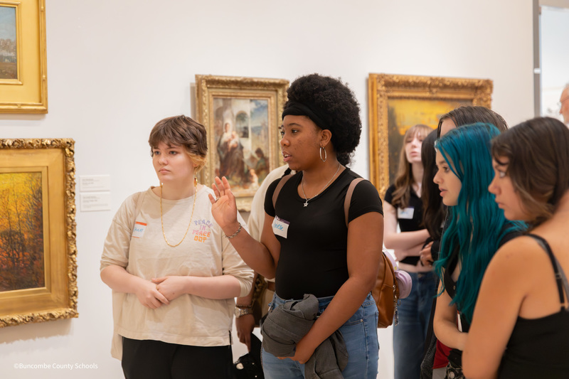student raising their hand to ask a question