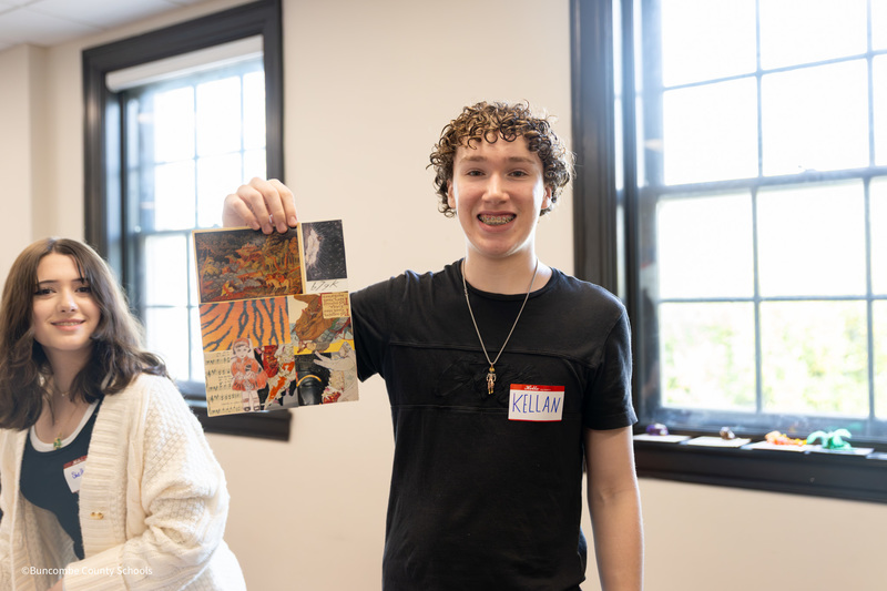 student holding self portrait