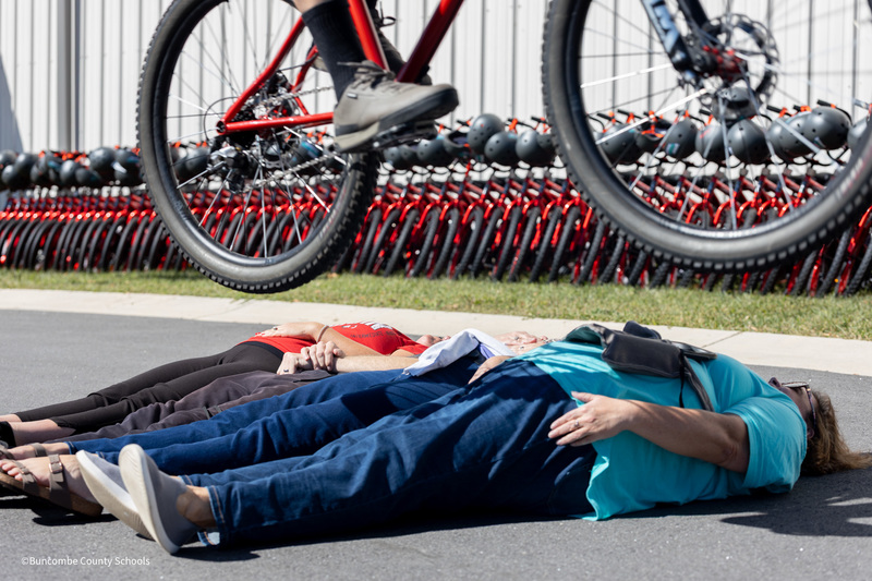 Biker jumping over teachers