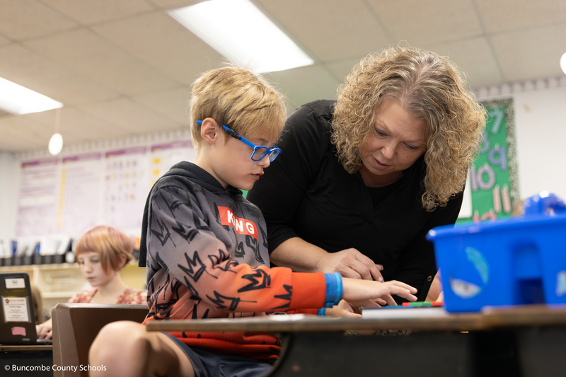 Kelly Owen helping a third grade with a math problem. 