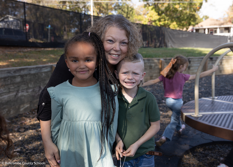 Kelly Owen with two students on the playground. 