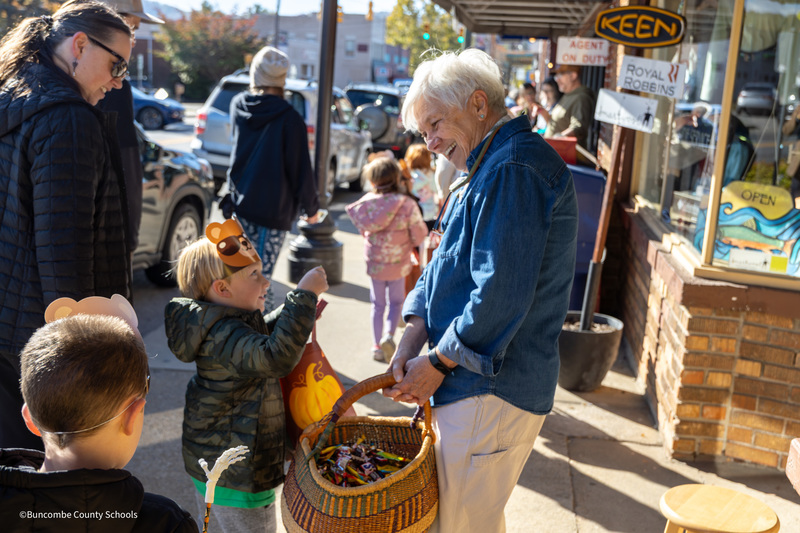 student getting candy from community member