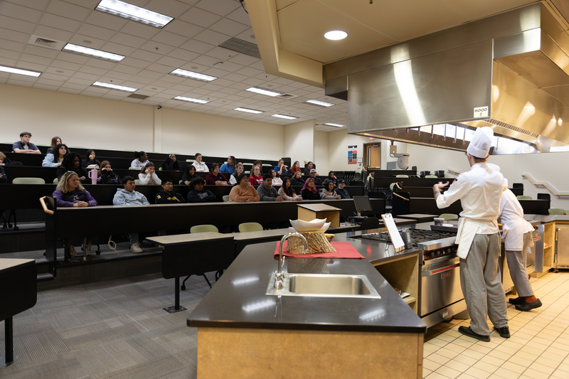 Auditorium of students watching the pastry students demonstrate how to make croissants.