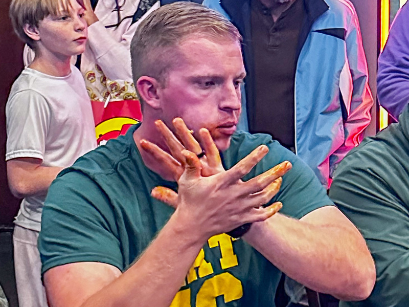 Coach Greer clapping with wing sauce all over his fingers