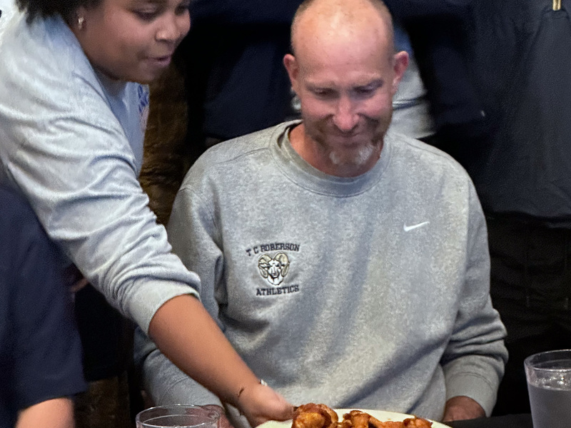 Coach Keen gets served a plate of wings by a Wild Wing Cafe server