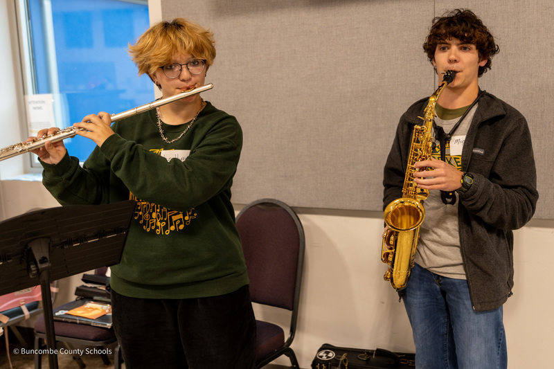 A student with a flute and a student with a saxophone perform