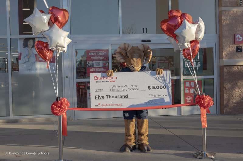 The Roberson Ram mascot stands in front of the Burlington store holding the giant $5000 novelty check