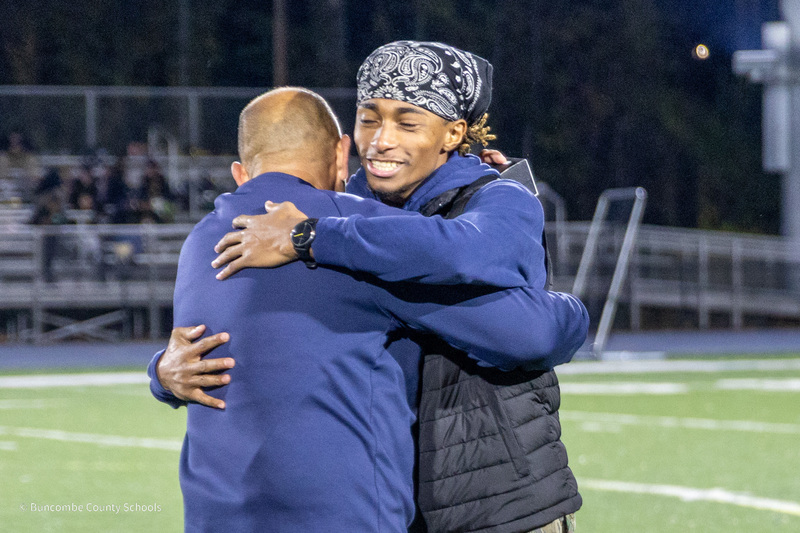 A baseball player hugs Coach Filipek