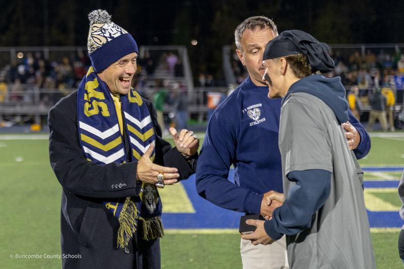 Dr. Jackson and Mr. Allison congratulate a player who has just received his ring