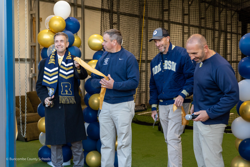 Dr. Jackson and Mr. Allison join the Roberson baseball coaches with a piece of the ribbon they've just cut to open the school's batting facility