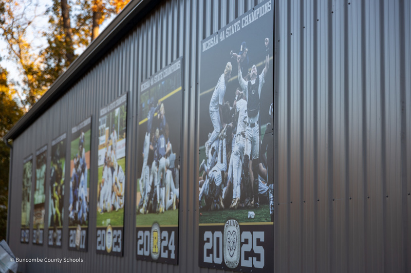 The exterior of the Roberson batting facility adorned with large posters of teams that have won state championships