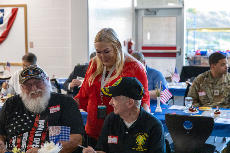Board of Education member Kim Plemmons speaks with two veterans attending the lunch