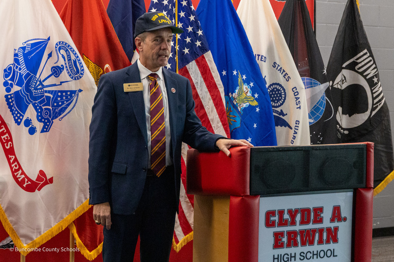 BCS Superintendent Dr. Rob Jackson stands in front of military flags addressing the crowd