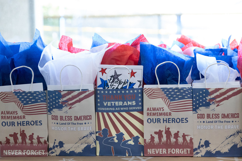 Red, white, and blue gift bags sit on table in front of a window at Erwin High School