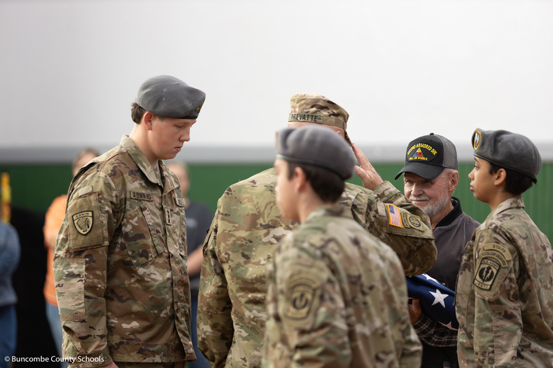 The JROTC presenting a veteran with the folded American flag. 