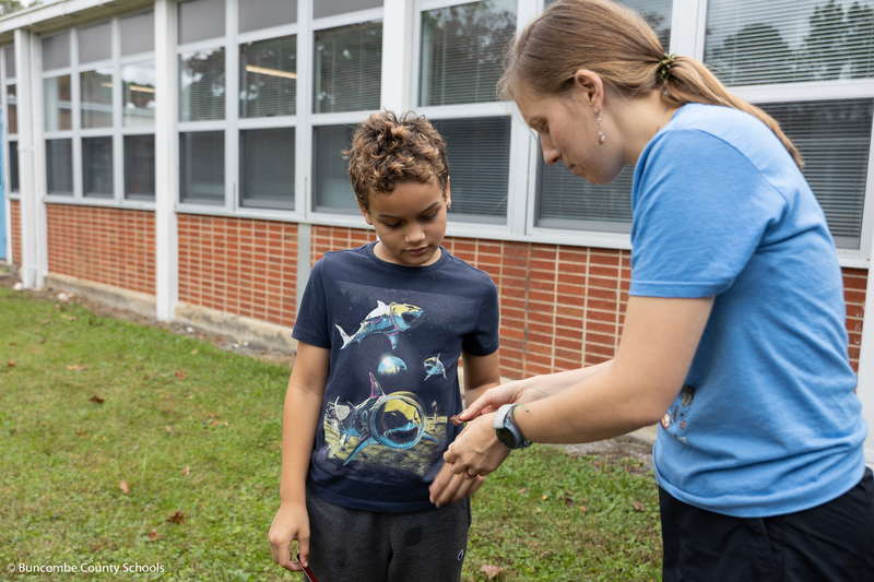 Nature center staff showing a little boy something.