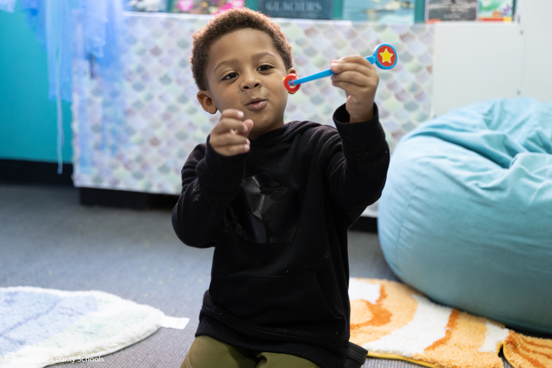 Little boy sitting on the floor playing a learning game.