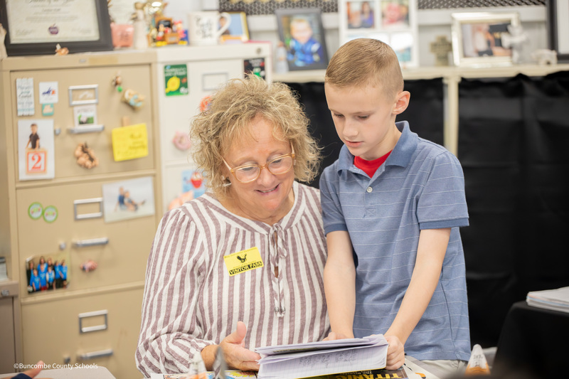 student showing his grandmother his work