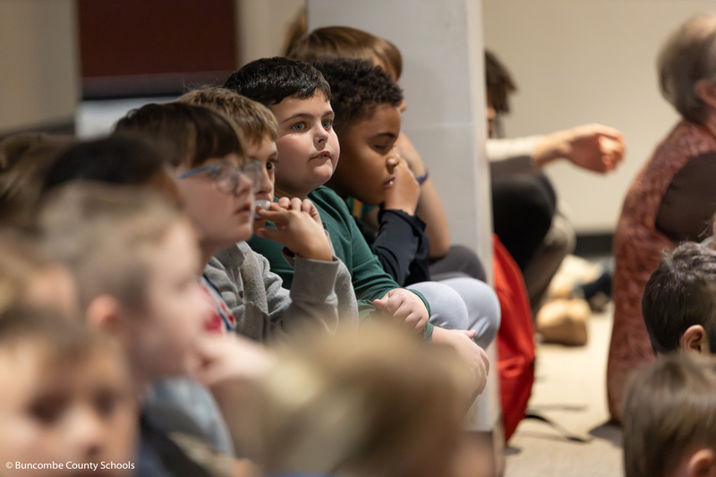 Children listening intently to the story as officers read the book.