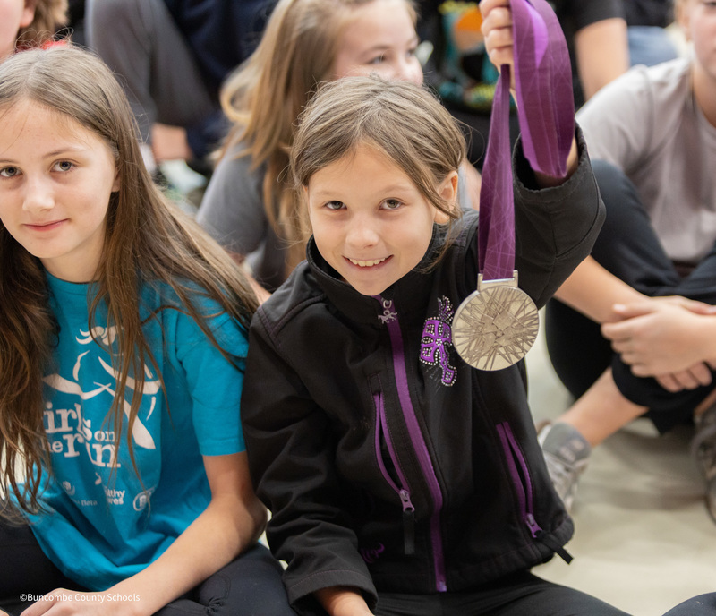 student holding medal