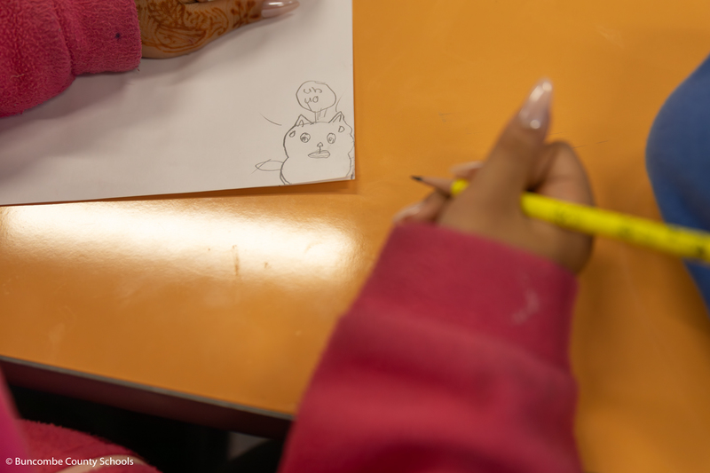 Photo of a students cartoon cat that was drawn on paper. 