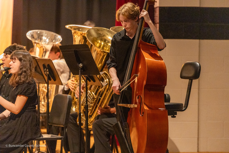 A student plays a stand-up bass on stage