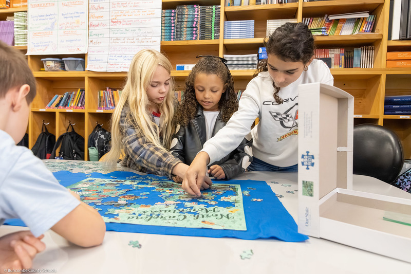 Three students work on a puzzle.