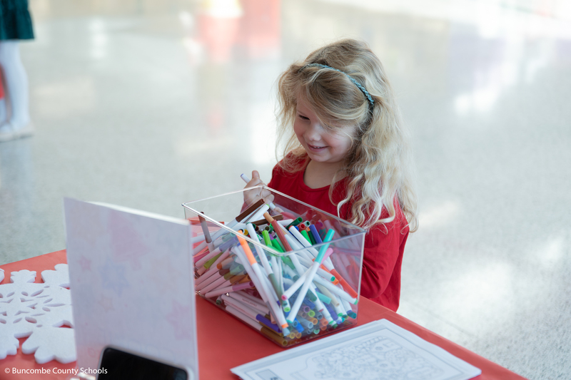 Little girl making a craft and smiling. 