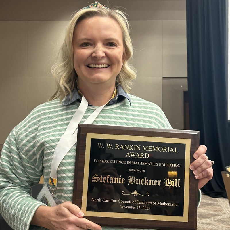 Ms. Hill poses holding her award plaque