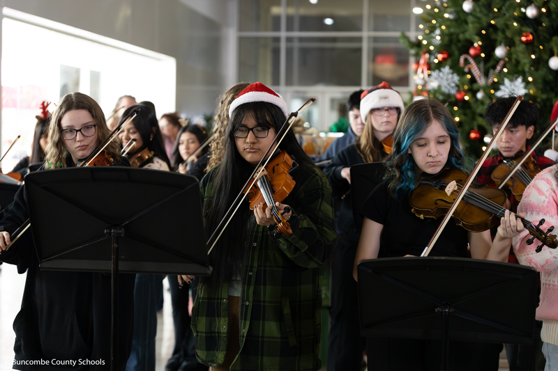 Group of girls playing the violin.