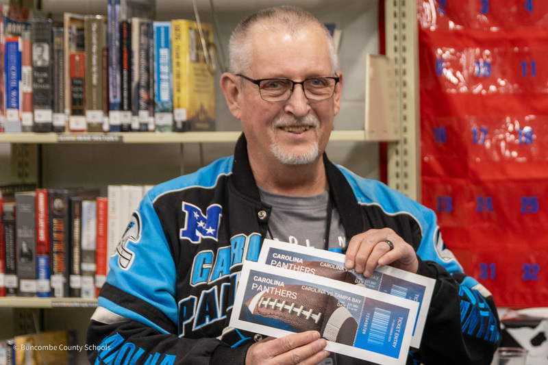 Mr. Maney smiles as he holds two Panthers tickets.