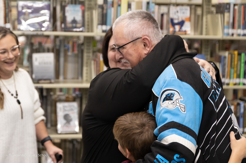 Mr. Maney gets hugged by his wife and his grandson.
