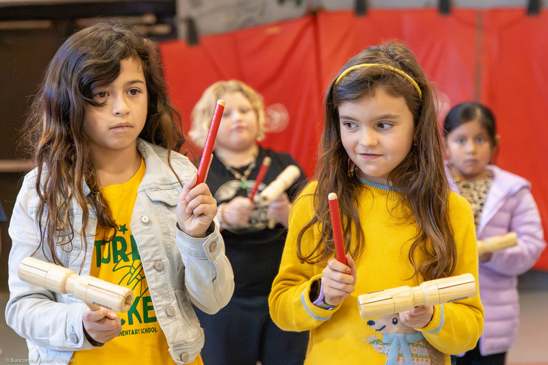 Two students use wood blocks to keep rhythm.