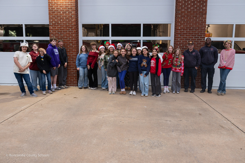 A photo of the Cane Creek teachers and students standing outside fo the Fairview Fire Station with two firefighters