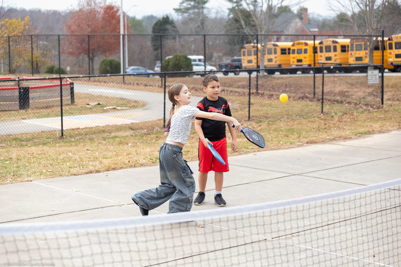 Two students play pickleball.
