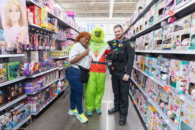A Walmart employee and SRO pose with the Grinch.