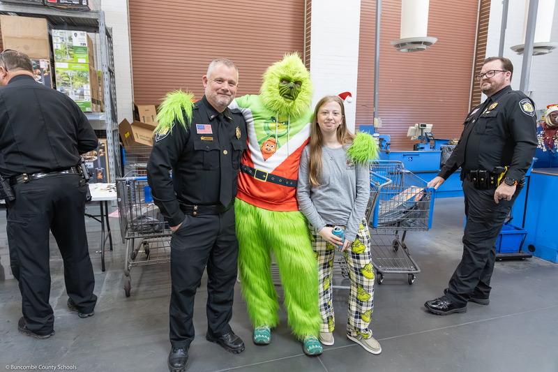 A student and SRO pose with the Grinch.
