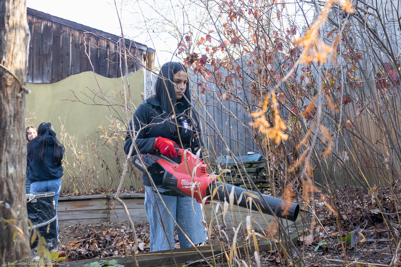 A student helps clean up the grounds of WNC Nature Center.
