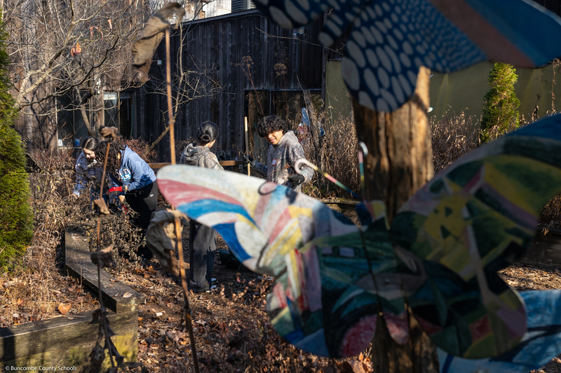 A student helps clean up the grounds of WNC Nature Center.