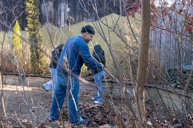 A student helps clean up the grounds of WNC Nature Center.