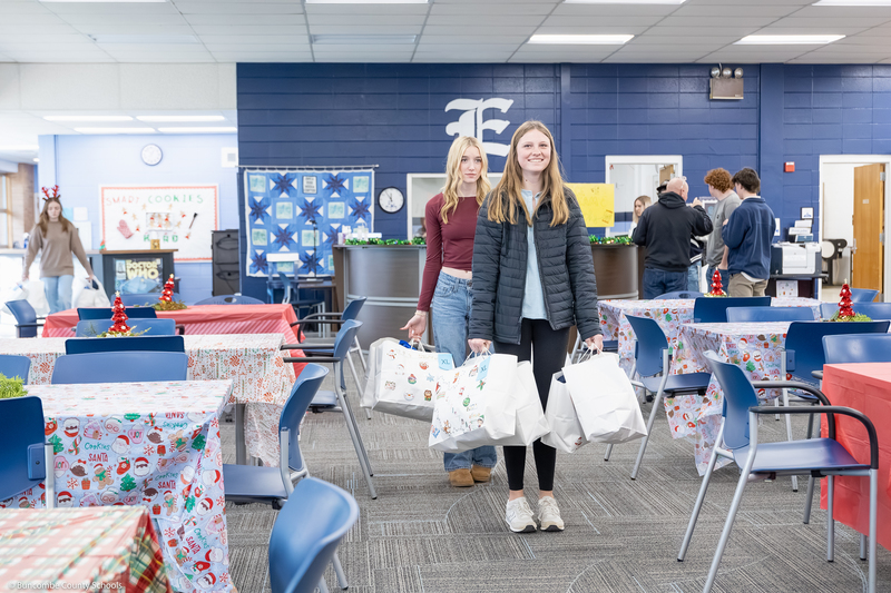 Enka High SGA members carry bags in the media center.