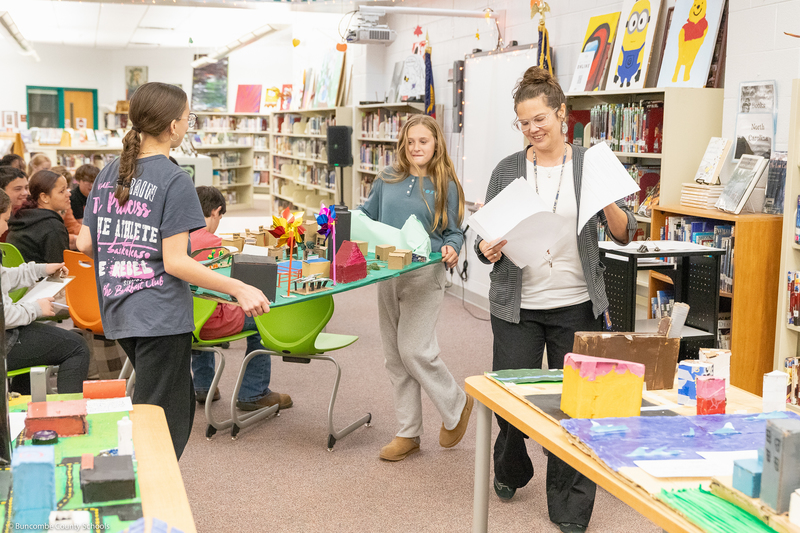 Students carry their Future City diorama on their way to give a presentation.