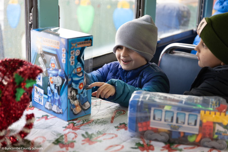 Little boy smiling and looking at the toy he just received.